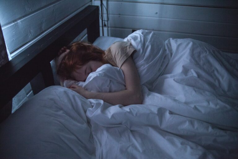 a woman asleep in bed not considering the ways your mattress is ruining your health