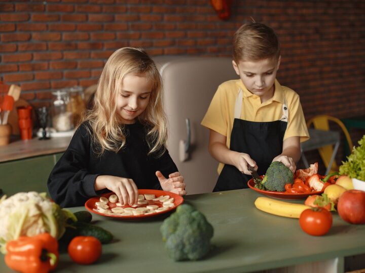 a little girl and boy preparing a meal as part of a balanced diet for children