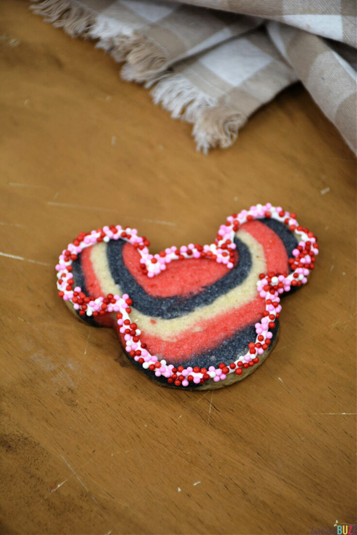 add valentine's sprinkles to edge of mickey mouse cookie