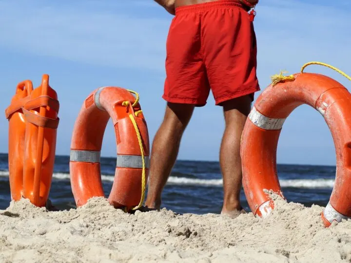 how to become a volunteer surf lifesaver like this one standing on the beach
