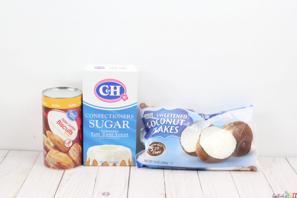 Canned biscuits, coconut flakes, and a package of confectioners sugar on a white background
