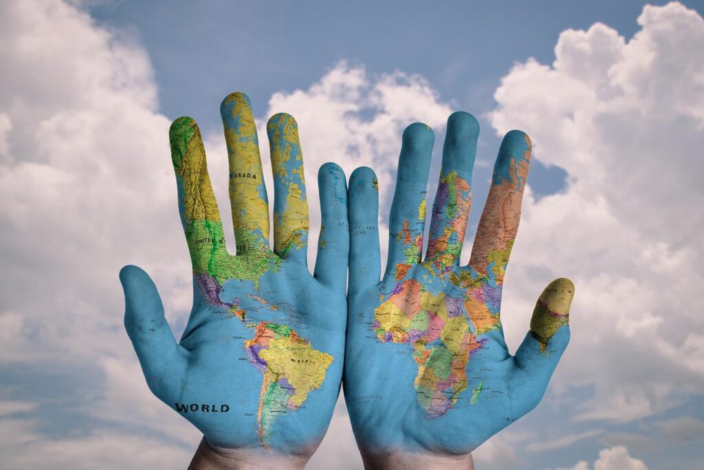 world map painted on two hands to show support of global issues