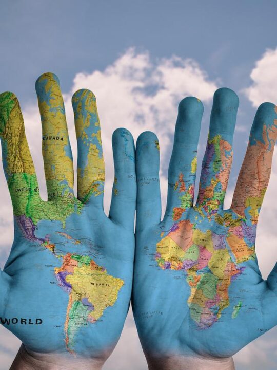 world map painted on two hands to show support of global issues