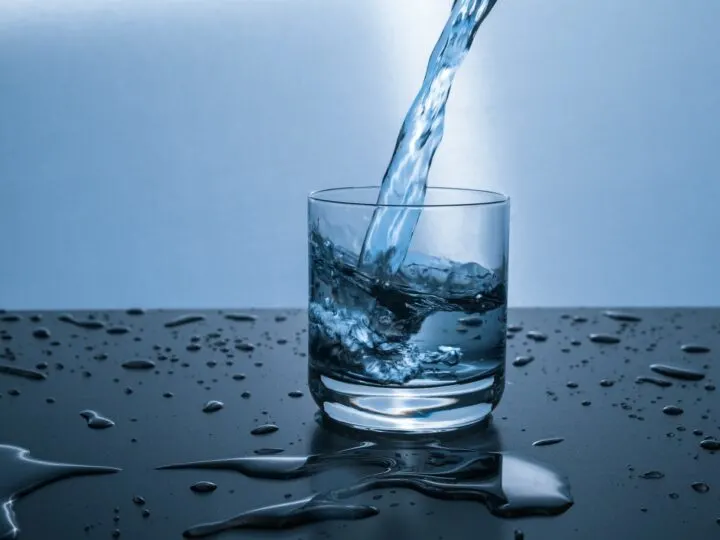 clean water from a water filtration system pouring into a glass