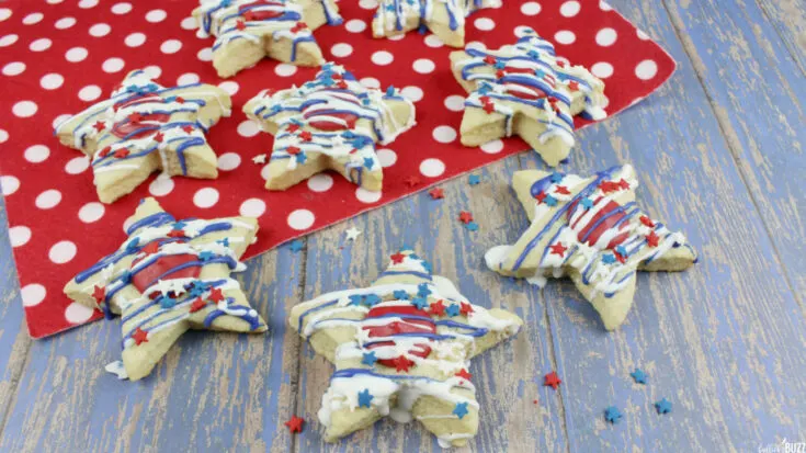 Red, White and Blue Patriotic Star Sugar Cookies spread out on blue background