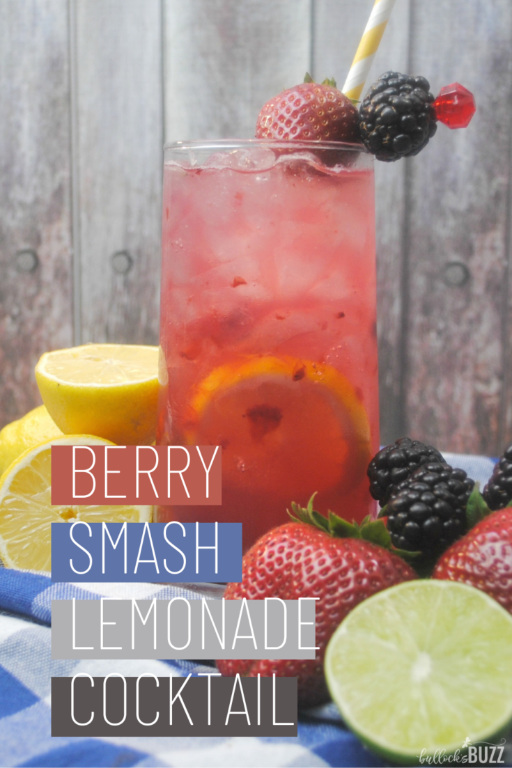 A tall glass of Berry Smash Lemonade Cocktail surrounded by fresh fruit