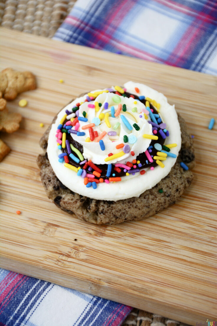 add rainbow sprinkles to frosted cookie