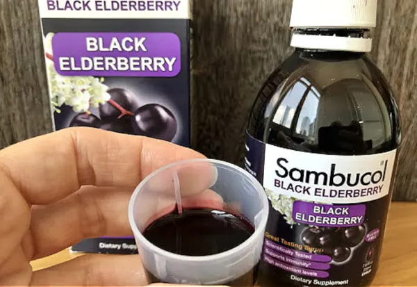 Sambucol black elderberry syrup in dosing cup