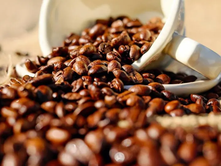 decaf coffee beans spilling out of cup