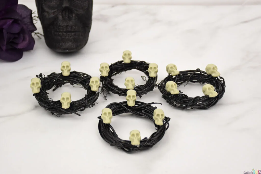 four Halloween napkin rings in front of a black skull