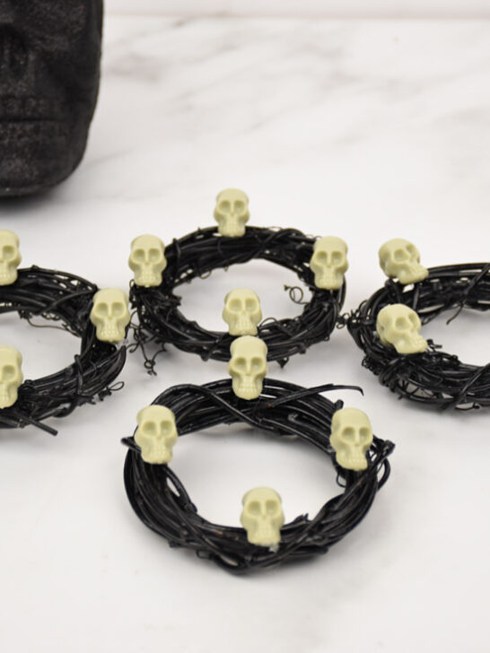 four Halloween napkin rings in front of a black skull