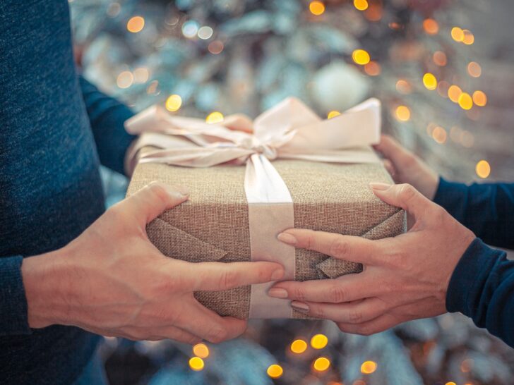 man and woman exchanging a gift from this list of the best gifts to buy for your partner