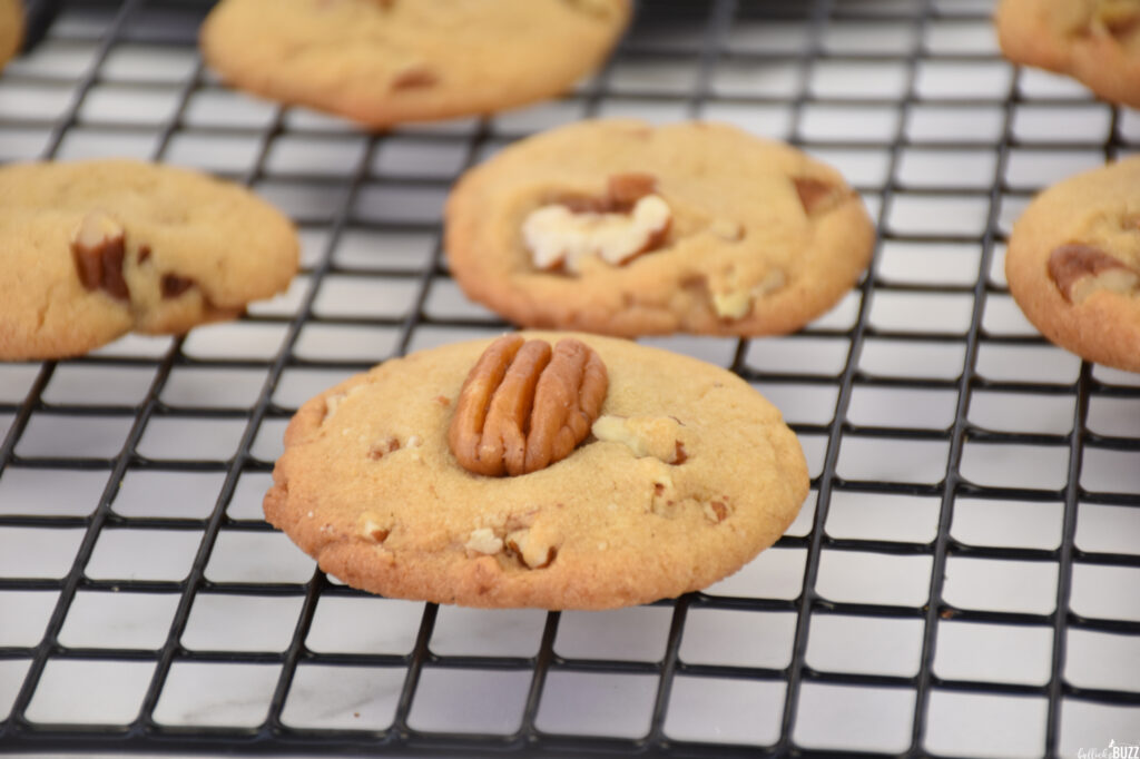 close up of pecan-topped  cookie on cooling rack