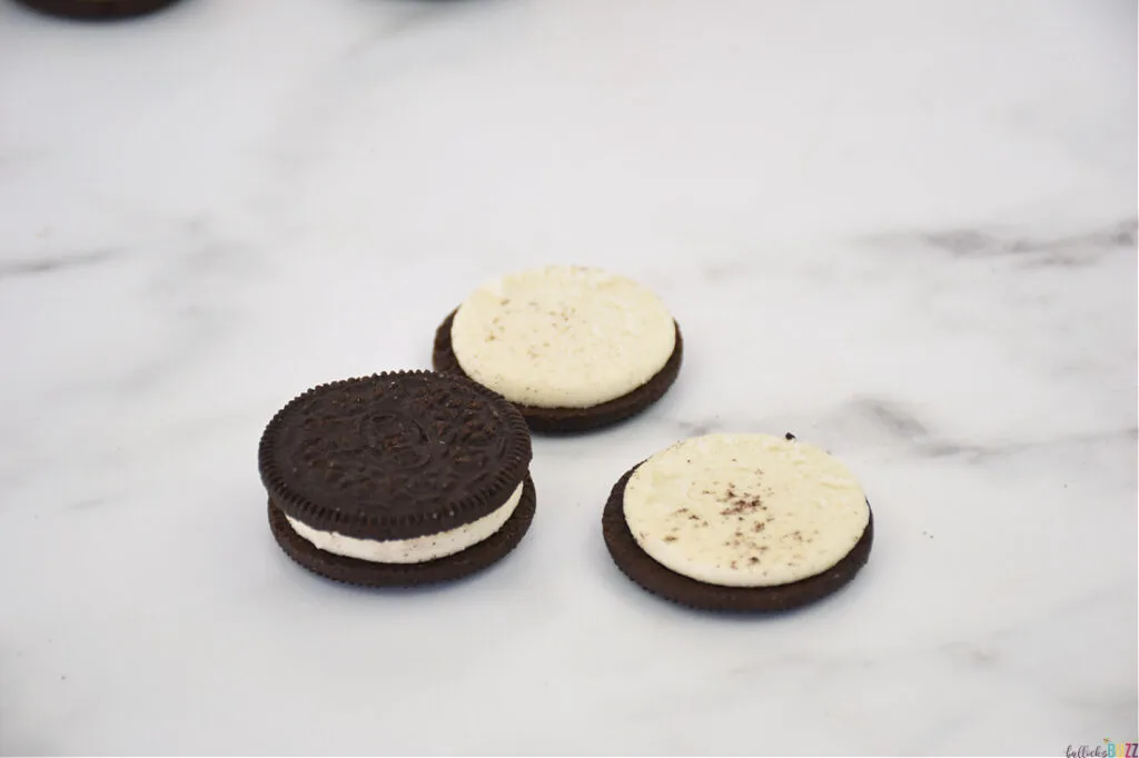 two cookie sides with frosting being pressed together