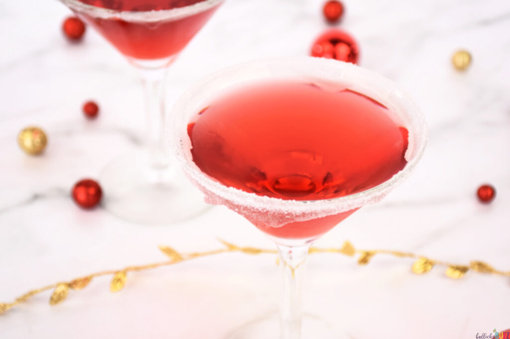 red Christmas cocktail in glass rimmed with sugar
