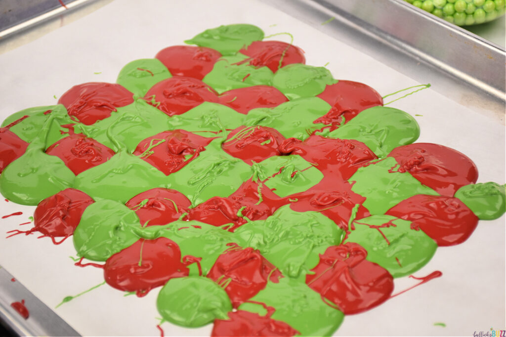 alternate adding melted red and green candy melts on parchment paper