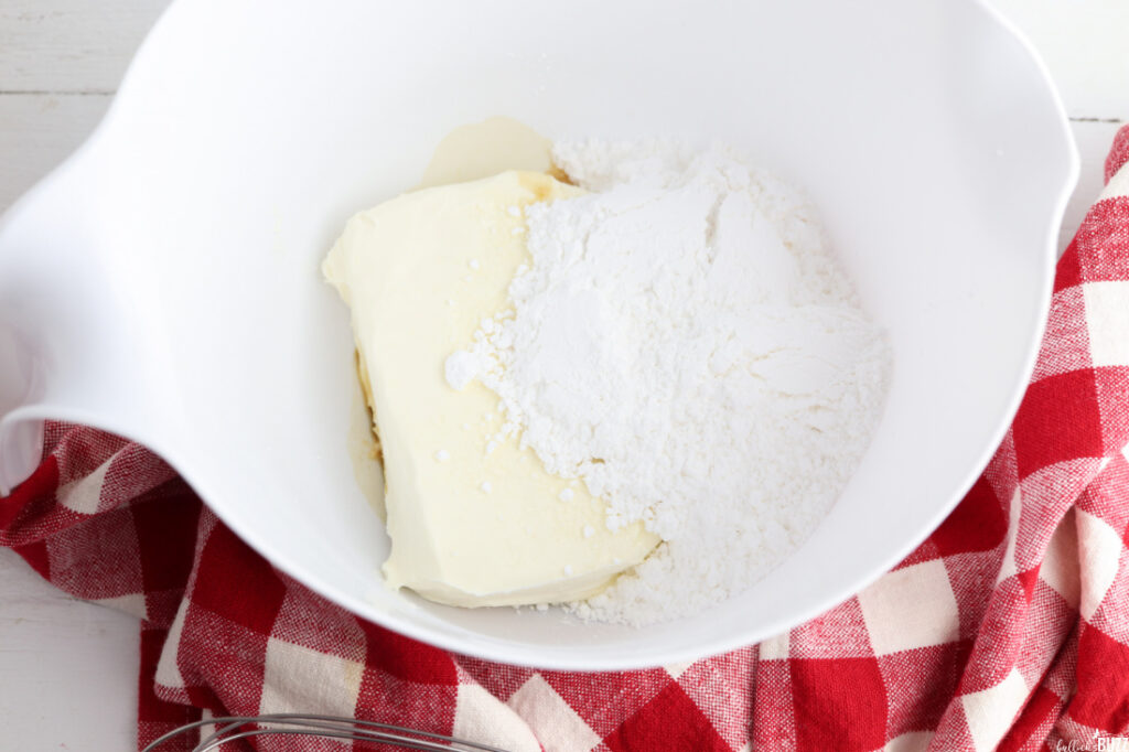 cream cheese, pwdered sugar and vanilla in a white mixing bowl
