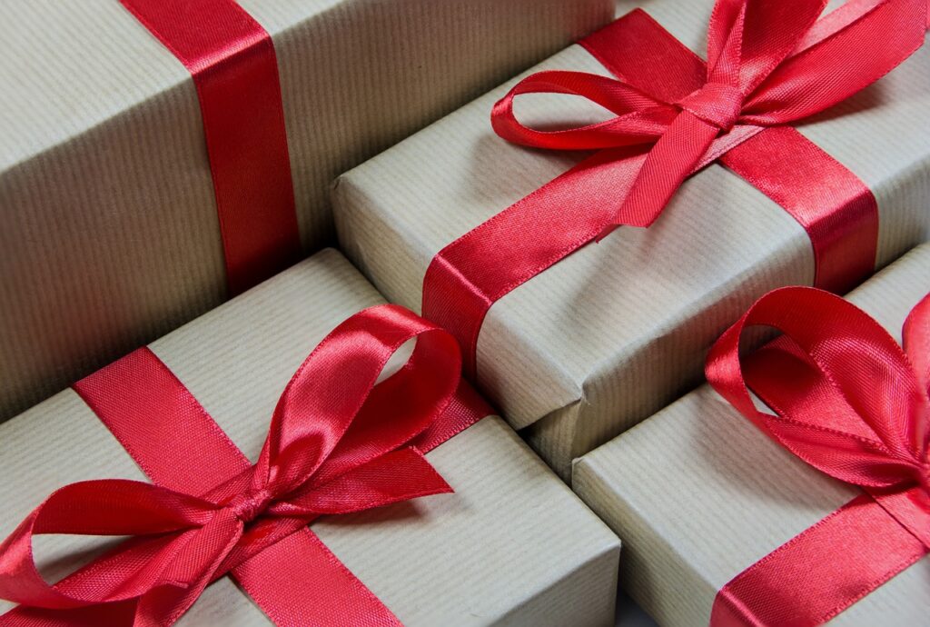several employee appreciation gifts wrapped in striped paper and tied with red ribbon