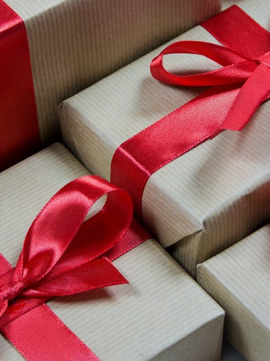 several employee appreciation gifts wrapped in striped paper and tied with red ribbon