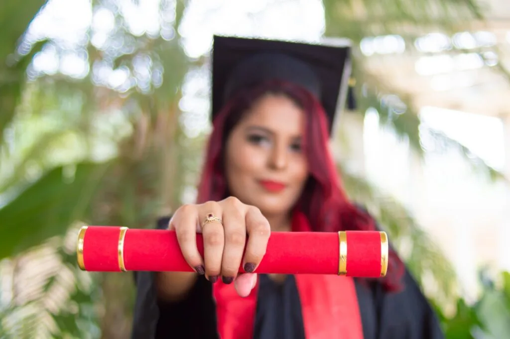 graduate holding out her diploma