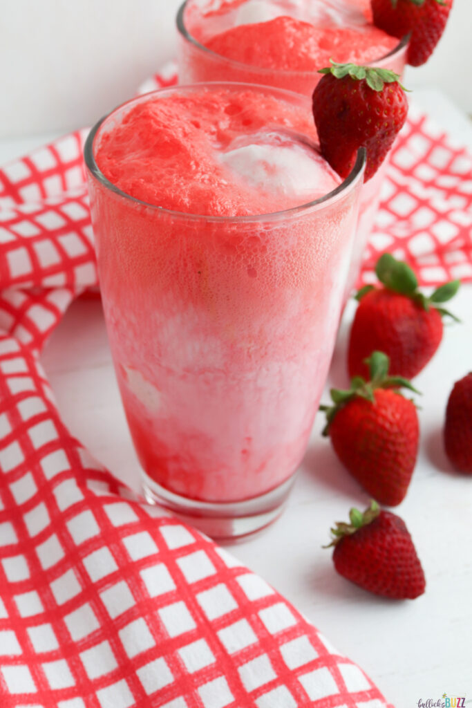 strawberry syrup, strawberry soda, and vanilla ice cream mixed together in a glass 
