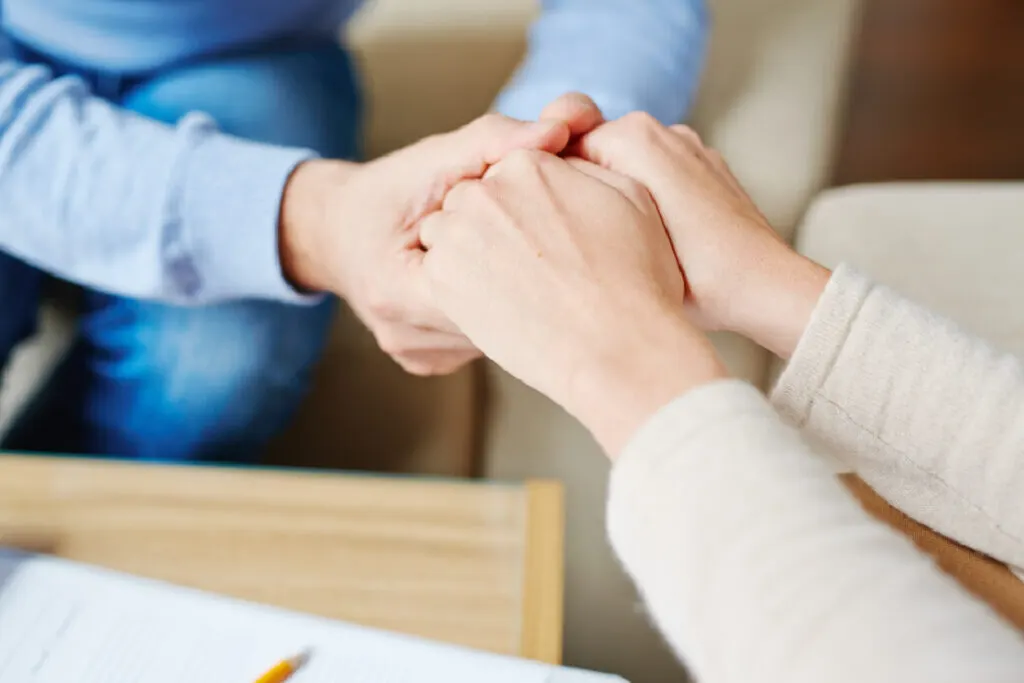 two people holding hands in a show of support