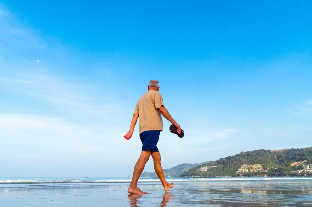 retired man walking on the beach