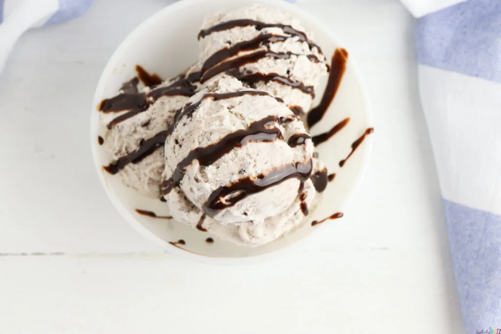 drizzle chocolate syrup on top of ice cream in bowl