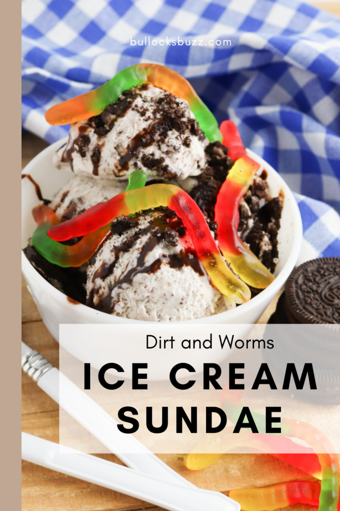 cookies and cream ice cream in a bowl topped with crushed Oreo cookies, drizzled with chocolate syrup, and finished with colorful gummy worms to make a dirt and worms ice cream sundae