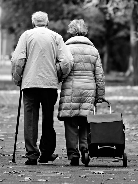 elderly man and woman walking together