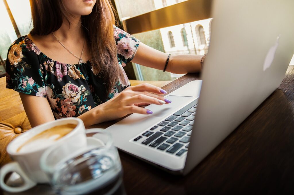 a cup of coffee at work like this woman has on her desk makes the Necta Krea a great coffee machine for the workplace kitchen