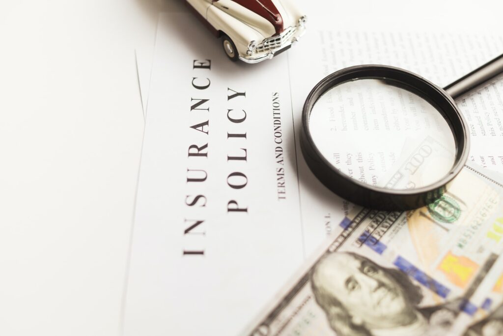 this magnifying glass on insurance papers emphasizes the importance of reading the fine print as part of tips on finding the right insurance policies for your needs