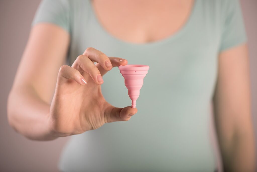 woman holding a menstrual cup and sharing about menstrual cup myths and facts