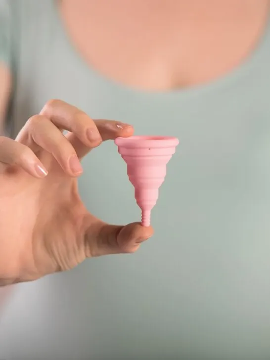 woman holding a menstrual cup and sharing about menstrual cup myths and facts