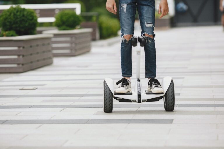 person hoverboard riding on a sidewalk