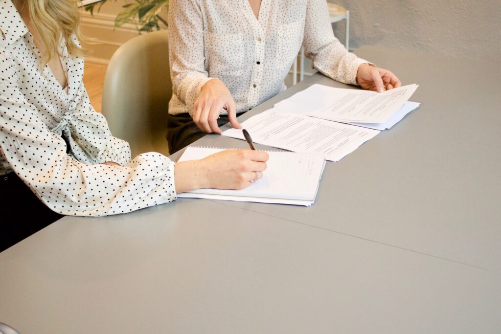 woman signing document after learning reasons why you need a lawyer after an accident