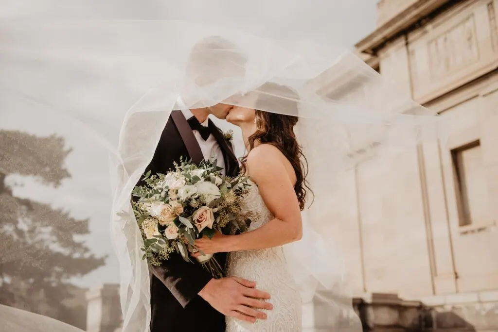 bride and groom kissing under her veil