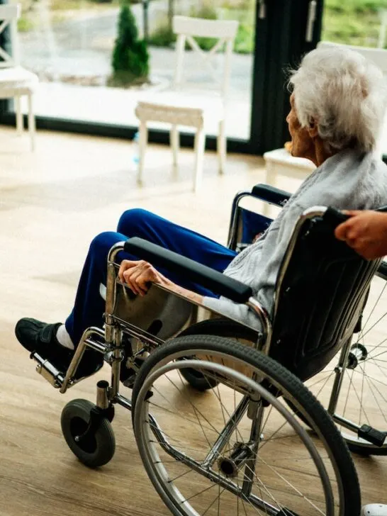 nurse pushing elderly woman in a wheelchair showing the importance of staff involvement when choosing the right nursing home