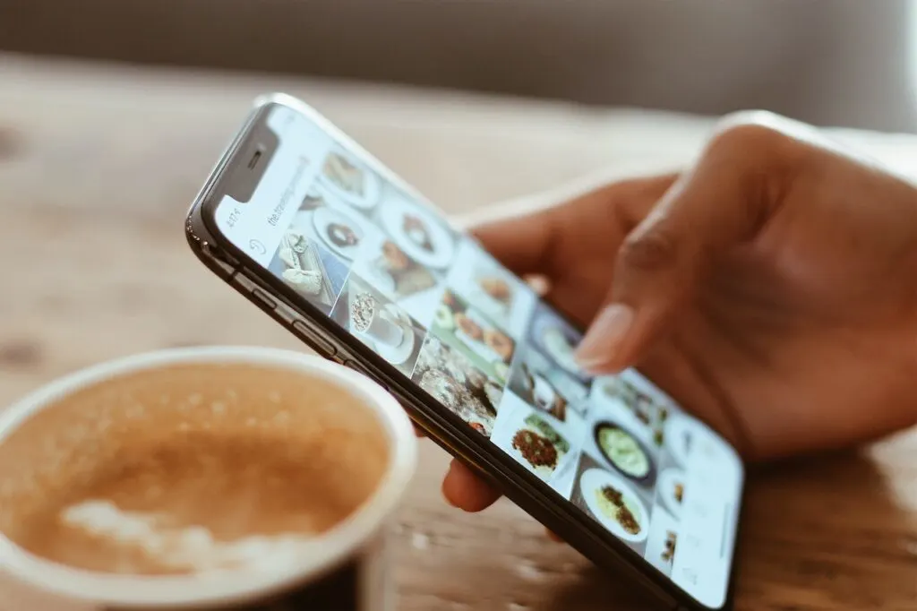 person holding phone posting on social media as a way of making social media work for you