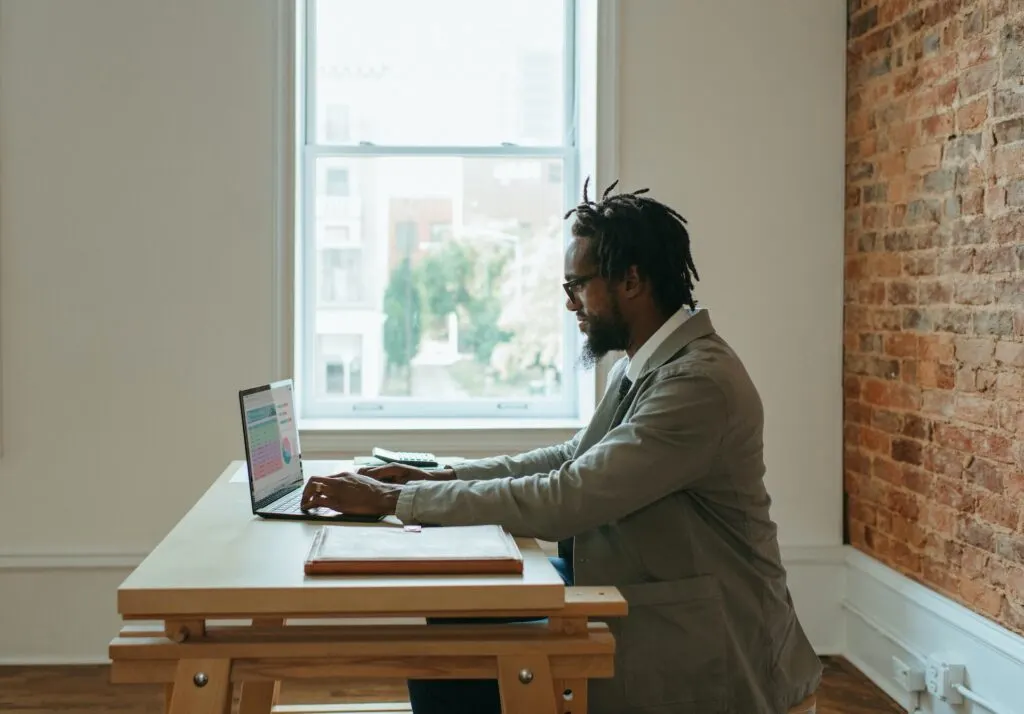 man sitting at table working on computer