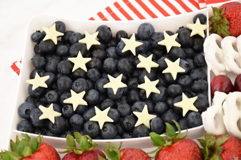 add the star shaped cheese on top on the blueberries