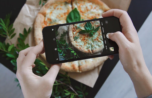 person taking overhead photo of food with her phone as part of our food photography tips