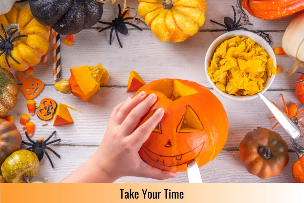 person carefully carving a smile in a pumpkin while learning how to carve a pumpkin