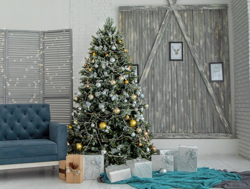 a silver and gold decorated Christmas tree surrounded by wrapped presents