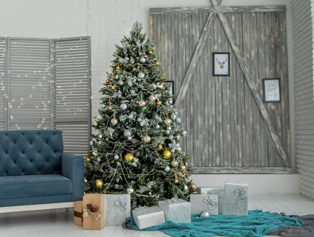 a silver and gold decorated Christmas tree surrounded by wrapped presents