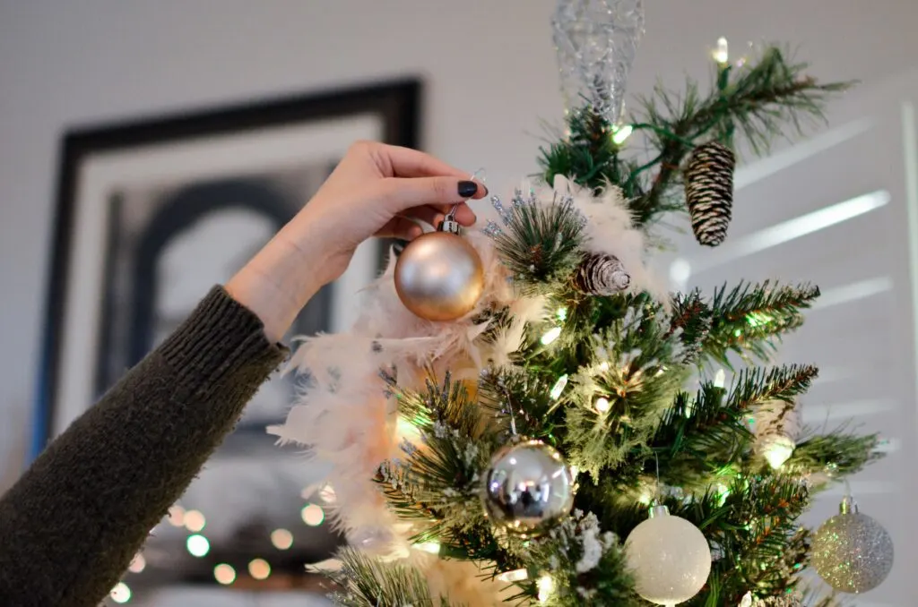 woman adding ornaments after choosing the perfect christmas tree for her home