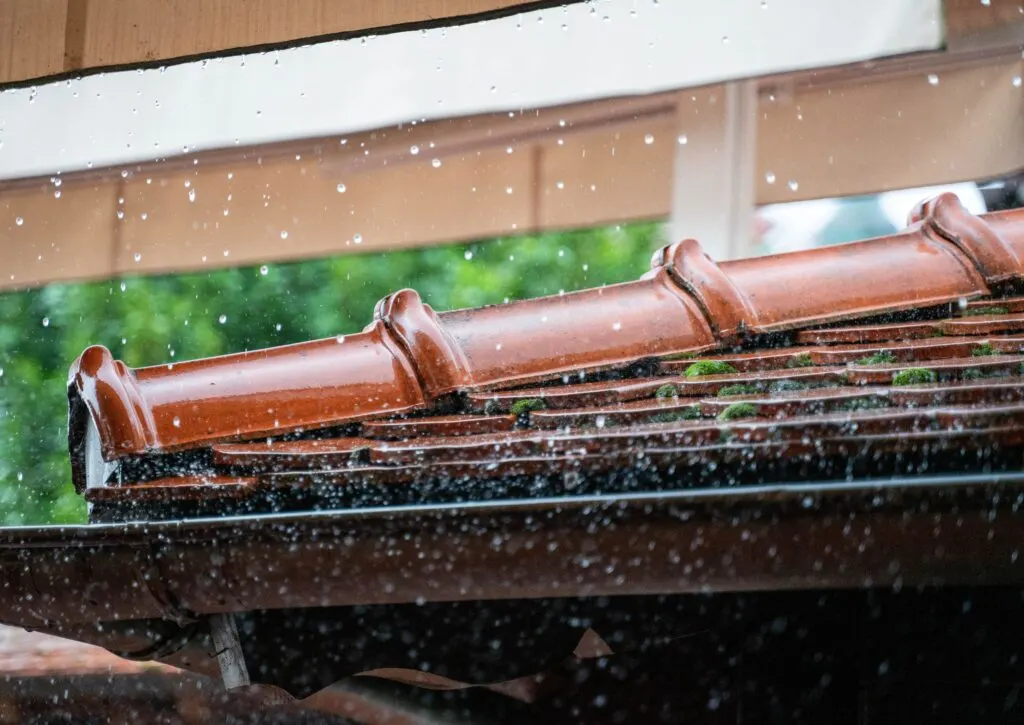 rain falling on a roof where cleaning your gutters is done regularly