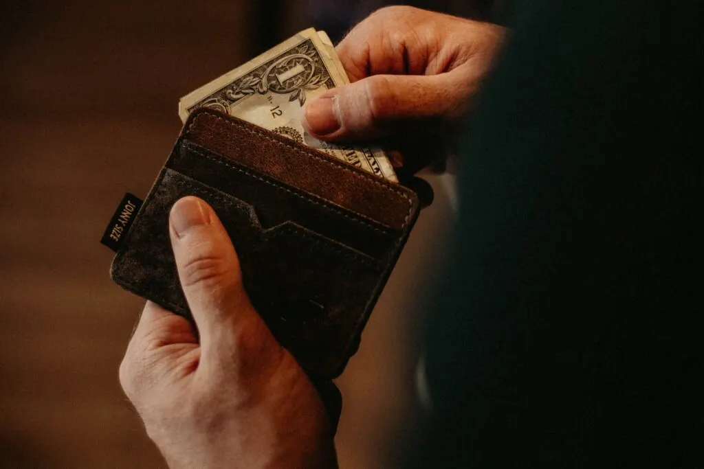 person adding money to their wallet