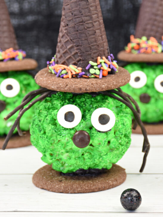 Close up of Halloween Popcorn Ball Witches treat made from popcorn balls, ice cream cones, cookies and candy.