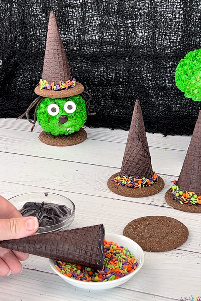 Rolling the end of an ice cream cone in Halloween sprinkles.